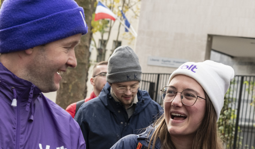 people in purple laughing and holding Volt flyers
