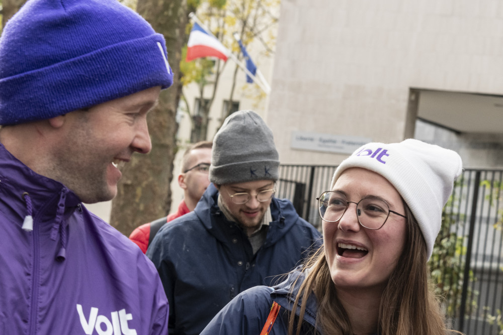 people in purple laughing and holding Volt flyers