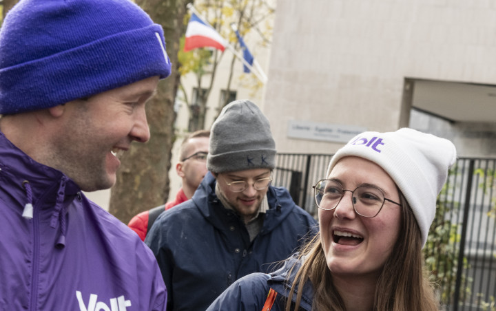 people in purple laughing and holding Volt flyers