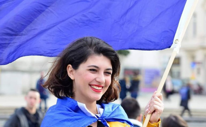 Nini Tsiklauri holding a large EU flag.