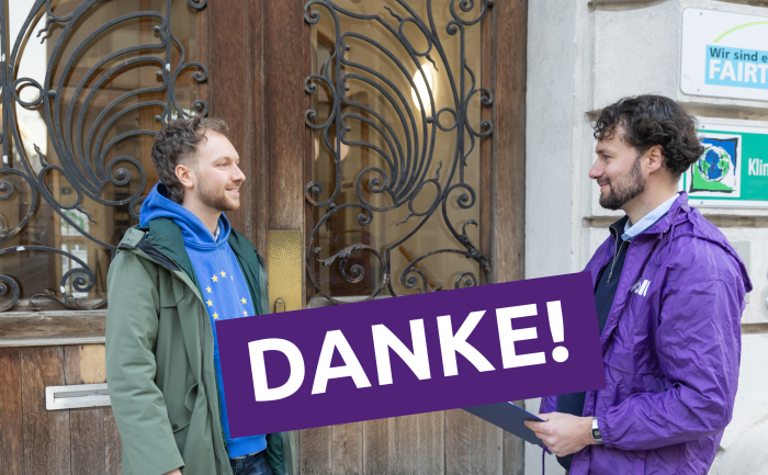 lead candidate Marek talking to someone and a big sign saying