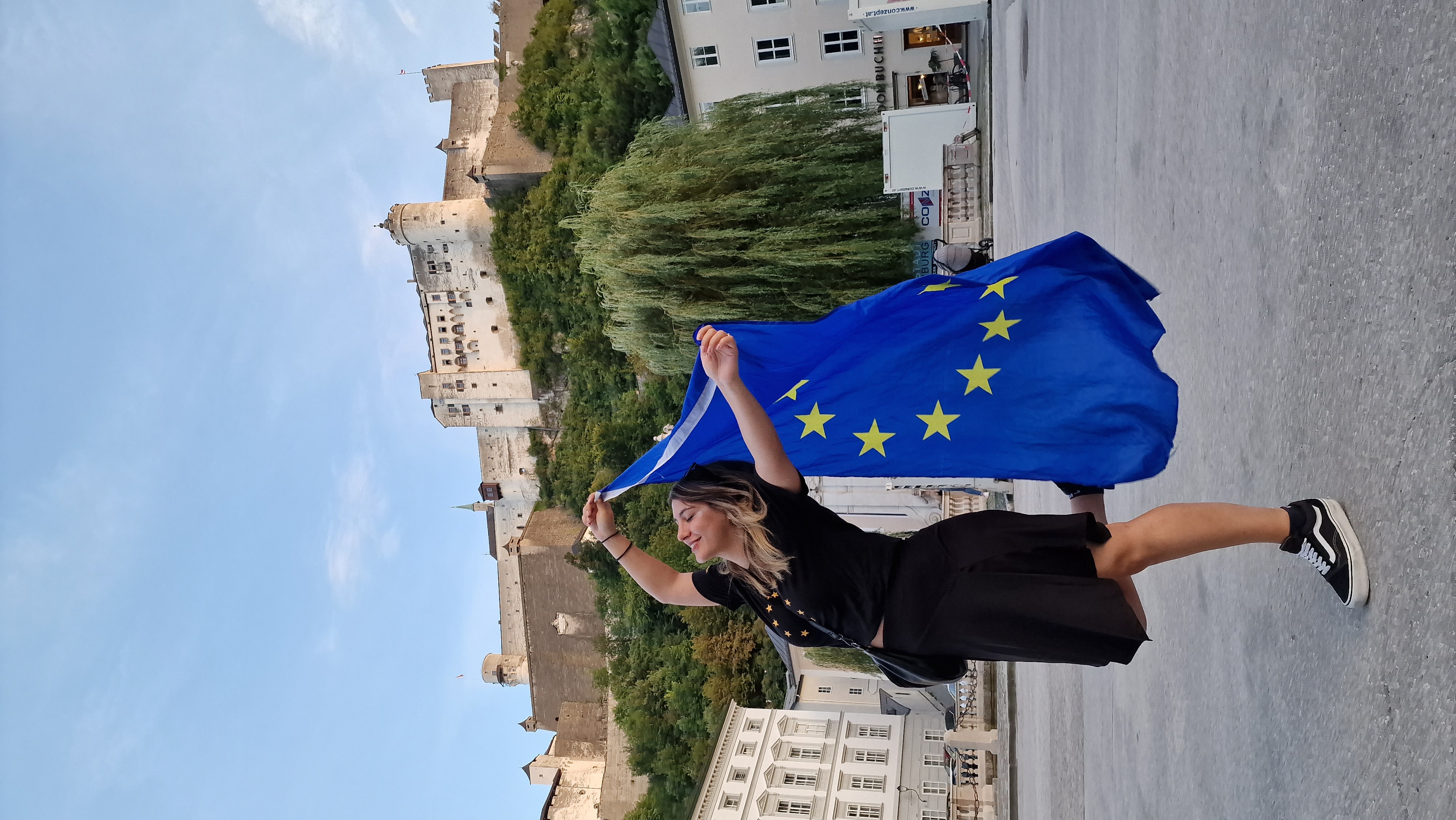 Nini Tsiklauri with a EU flag in front of the Hohensalzburg.